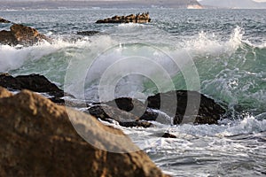 Ocean waves hitting the rocky sea beach.