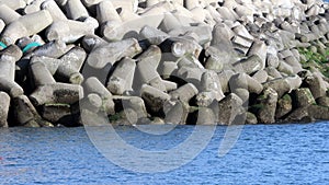 Ocean waves lapping against pier of tetrapod