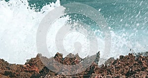 Ocean waves swelling and crashing onto the rocky shore in Caribbe