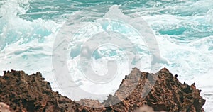 Ocean waves swelling and crashing onto the rocky shore in Caribbe