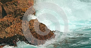 Ocean waves swelling and crashing onto the rocky shore in Caribbe