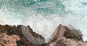 Ocean waves swelling and crashing onto the rocky shore in Caribbe