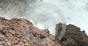 Ocean waves swelling and crashing onto the rocky shore in Caribbe