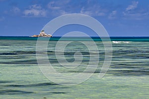 Ocean waves, turquoise water and baby blue sky. Anse A La Mouche, Mahe Island, Seychelles.