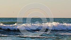 Ocean waves and water crashing on to sandy beach