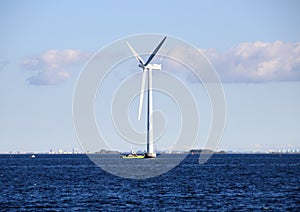 Ocean windmill in rough sea with inspection ship