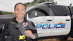 Oceanside, CA / USA - October 27, 2019: A friendly young female police officer of mixed ethnicity