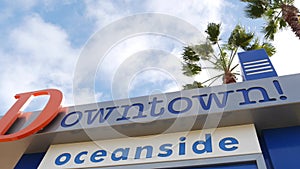 Oceanside nameboard sign and palm trees. Oside is the popular american tourist resort, pacific ocean west coast, San