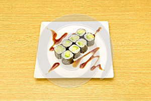 Ocho piezas de sushi maki de aguacate maduro con arroz japones, algas nori photo