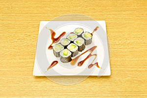 Ocho piezas de sushi maki de aguacate maduro con arroz japones, algas nori