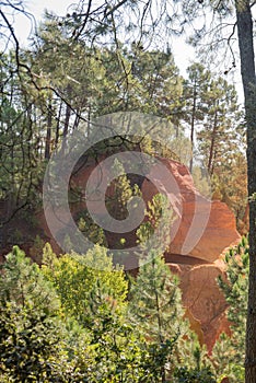 Ochre Trail in Roussillon, Sentier des Ocres, hiking path in a natural colorful area of red and yellow cliffs surrounded by green