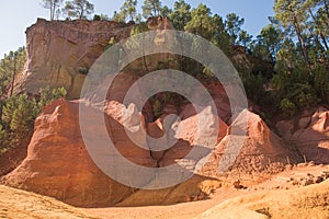 Ochre Trail in Roussillon, Sentier des Ocres, hiking path in a natural colorful area of red and yellow cliffs surrounded by green