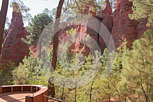 Ochre Trail in Roussillon, Sentier des Ocres, hiking path in a natural colorful area of red and yellow cliffs surrounded by green