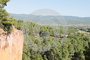 Ochre Trail in Roussillon, Sentier des Ocres, hiking path in a natural colorful area of red and yellow cliffs surrounded by green