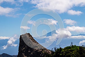 ock formation with scenic view on the cloud covered volcano mountain peak Pico del Teide on Tenerife seen from La Gomera