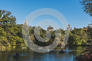 Locals rowing boats in a lake in central park, in a sunny autumn day