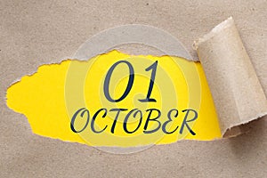 october 01. 01th day of the month, calendar date.Hole in paper with edges torn off. Yellow background is visible through