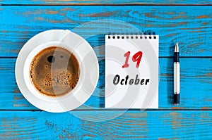 October 19th. Day 19 of october month, calendar on workbook with coffee cup at student workplace background. Autumn time