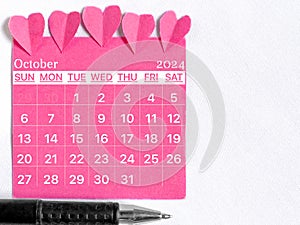 October 2024 calendar with pink color background. Women health concept. Stock photo.