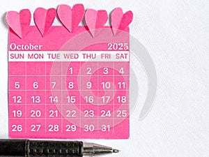October 2025 calendar with pink color background. Women health concept. Stock photo.