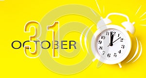 October 31st . Day 31 of month, Calendar date. White alarm clock with calendar day on yellow background. Minimalistic concept of