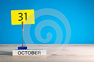 October 31st. Day 31 of october month, calendar on workplace with blue background. Autumn time. Empty space for text