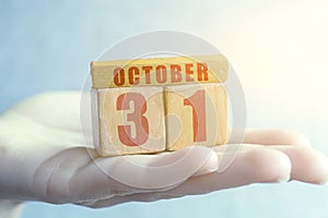 october 31st. Day 31of month,Handmade wood cube with date month and day on female palm autumn month, day of the year concept