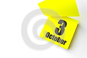 October 3rd. Day 3 of month, Calendar date. Close-Up Blank Yellow paper reminder sticky note on White Background. Autumn month,