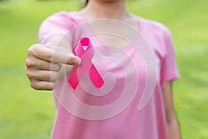 October Breast Cancer Awareness month, adult Woman in pink T- shirt with hand holding Pink Ribbon for supporting people living and