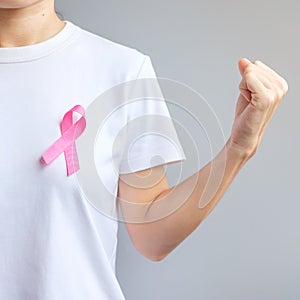 October Breast Cancer Awareness month, elderly Woman in white T- shirt with Pink Ribbon and fist sign for supporting people living