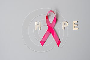 October Breast Cancer Awareness month, Pink Ribbon with HOPE text on grey background for supporting people living and illness.