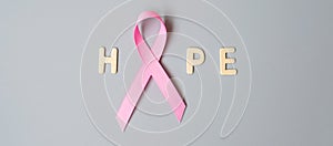 October Breast Cancer Awareness month, Pink Ribbon with HOPE text on grey background for supporting people living and illness.