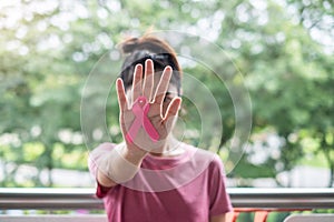 October Breast Cancer Awareness month, Woman in pink T- shirt with hand holding Pink Ribbon for supporting people living and