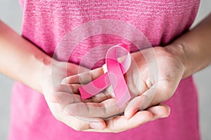 October Breast Cancer Awareness month, Woman in pink T- shirt with hand holding Pink Ribbon for supporting people living and