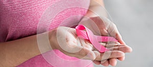 October Breast Cancer Awareness month, Woman in pink T- shirt with hand holding Pink Ribbon for supporting people living and