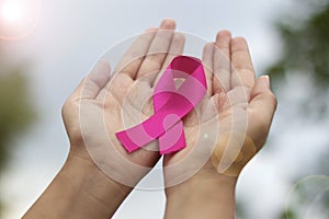 Breast cancer awareness. Woman hand holding pink ribbon
