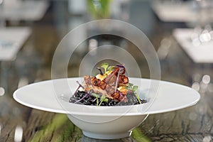 Octopus with black rice and herbs