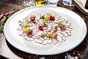 Octopus carpaccio. Spinach cream, cherry tomatoes. Delicious healthy Italian traditional food closeup served for lunch