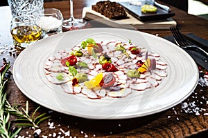 Octopus carpaccio. Spinach cream, cherry tomatoes. Delicious healthy Italian traditional food closeup served for lunch