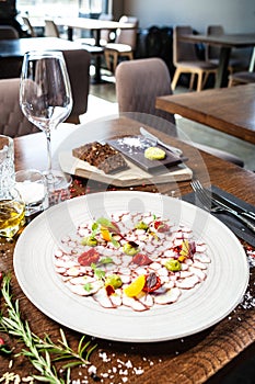 Octopus carpaccio. Spinach cream, cherry tomatoes. Delicious healthy Italian traditional food closeup served for lunch