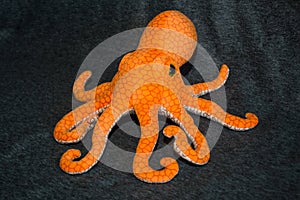 Octopus orange toy on grey background