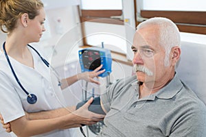 Octor checking blood pressure patient in hospital