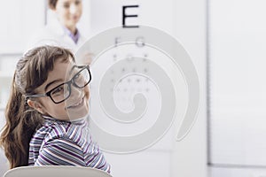 Oculist testing a young patient`s eyesight using an eye chart