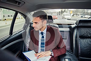 Ocupated businessman in a limo