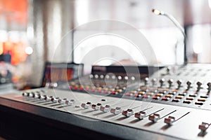 Od adjusters and red buttons of a mixing console. It is used for audio signals modifications to achieve the desired photo