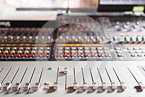 Od adjusters and red buttons of a mixing console. It is used for audio signals modifications to achieve the desired photo