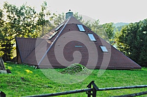 Odd building, house made of just a gable roof, no walls, three windows in roof