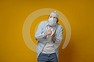 Oddball man in a medical mask is very afraid of contracting the virus, he put on a tin foil hat and looks upstairs in