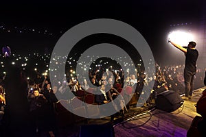 Odessa, Ukraine-circa 2019: large crowd of spectators at concert. Spectators in theater holds lighters and mobile phones at crowd