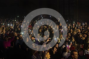 Odessa, Ukraine-circa 2019: large crowd of spectators at concert. Spectators in theater holds lighters and mobile phones at crowd